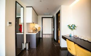 a kitchen with a table and yellow chairs in a room at The Saphire Palace by Anna Vũ in Ha Long