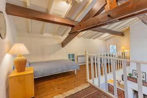 a bedroom with a bed and a staircase with wooden beams at Winemaker's Home By Pézenas Vineyards in Pézenas +31 photos