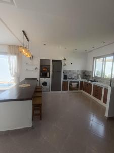 une grande cuisine blanche avec une grande île dans l'établissement Villa Ounaissa, à Tanger 44 autres photos