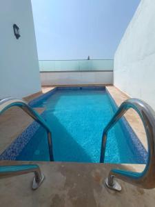 une piscine à l'eau bleue dans un immeuble dans l'établissement Villa Ounaissa, à Tanger