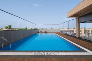 a swimming pool on the roof of a building at Hilton Garden Inn Surat City Centre in Surat