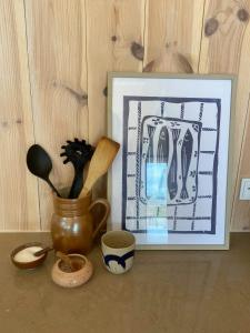 a picture of utensils in a pot next to a painting at Modern Summer House Overlooking The Water in Faaborg