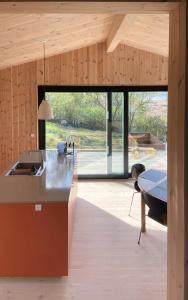 a kitchen with a counter and a table at Modern Summer House Overlooking The Water in Faaborg