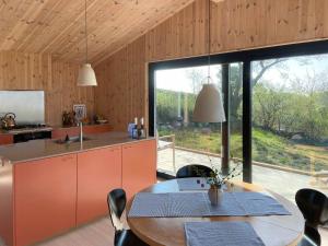 a kitchen with a table and a large window at Modern Summer House Overlooking The Water in Faaborg +32 photos