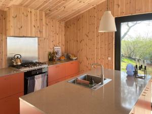 a kitchen with a sink and a stove at Modern Summer House Overlooking The Water in Faaborg