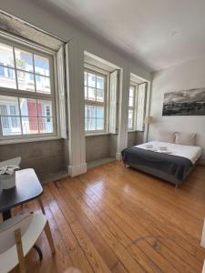 een slaapkamer met een bed en een aantal ramen bij Great&Cosy São Bento in Porto