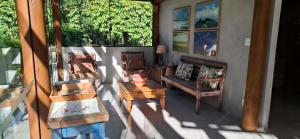 a living room with couches and a table on a porch at Villa do Cajueiro Imbassaí by LVF in Imbassai