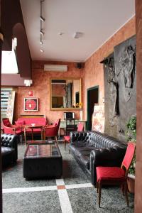 a living room with a black leather couch and red chairs at Da Mariuccia in Robecchetto con Induno