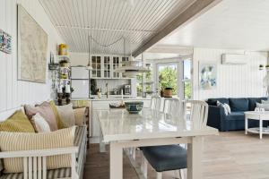 a kitchen and living room with a white table and chairs at Peaceful Nostalgic Home With A View in Ebberup