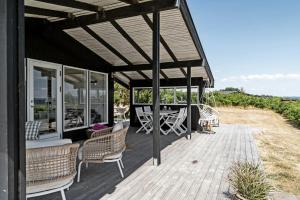 a wooden deck with chairs and a table on it at Peaceful Nostalgic Home With A View in Ebberup
