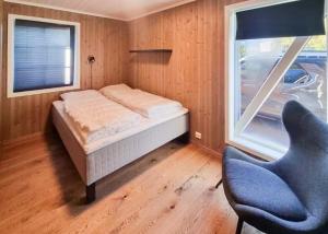 a bedroom with a bed and a chair and a window at Modern Family Cabin At Hovden Alpin in Hovden