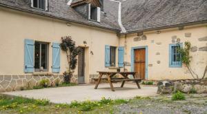 a wooden picnic table in front of a house at Chez Louise in Cauterets