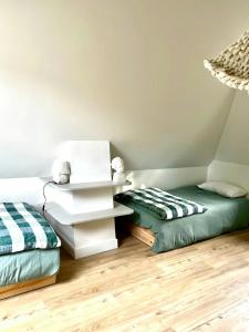 a room with two beds and a white table at Charming House In Lyons-La-Forêt in Lyons-la-Forêt