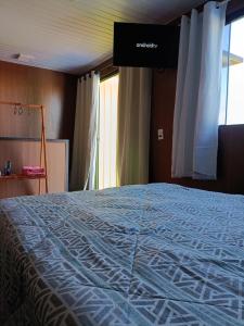 a large bed in a room with a window at sobrando aconchegante e privado in Dourados +19 photos