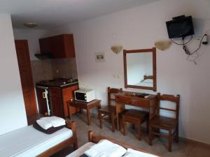 a room with a bed and a desk and a mirror at Hotel Kosmas in Sarti