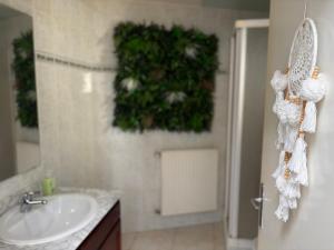 a bathroom with a sink and a green plant on the wall at La Casa Mexico - Terrasse & Parking privé in Trignac