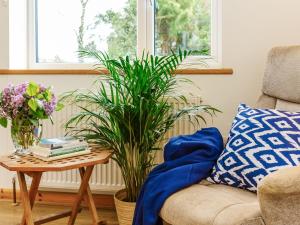 a living room with a couch and a table with plants at Woodlands in Milverton