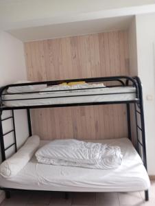 Ce lit superposé se trouve dans un dortoir doté d'un oreiller. dans l'établissement STUDIO 5 personnes N7 LUZ SAINT SAUVEUR draps et serviettes fournis, à Luz-Saint-Sauveur