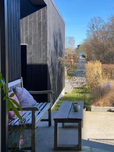 a bench and a table next to a building at Modern Beach House At Skæring Beach in Egå