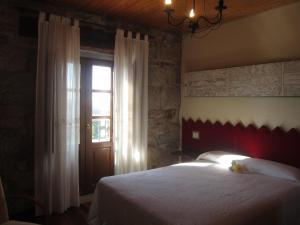 Un dormitorio con una cama grande y una ventana. en Las Horas Perdidas, en Moscán