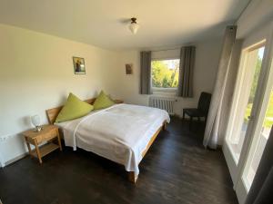 a bedroom with a bed with green pillows and a window at Café Pension Pfaus 1 fewo-4 Zimmer in Mühlenbach