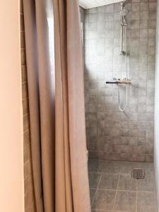 a shower with a shower curtain in a bathroom at Beach House Near Sejerø Bay in Hønsinge +14 photos