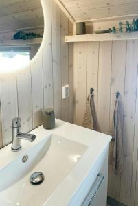 a bathroom with a white sink and a mirror at Cabin With Views In Langsua National Park in Heggenes +25 photos