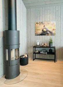 Una sala de estar con chimenea y televisión. en Luxury Cabin With Panoramic Views In Stranda, en Stranda