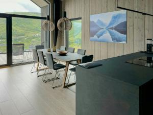Un comedor con mesa y sillas y ventanas. en Luxury Cabin With Panoramic Views In Stranda, en Stranda