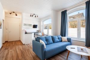 a living room with a blue couch and a table at Haus Kreihnsdörp, Ferienwohnung 1 in Grevesmühlen