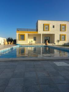 une grande piscine devant un immeuble dans l'établissement Huge entire private villa, à Temlale