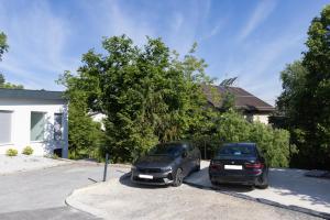 two cars parked in a parking lot in front of a house at Villa Andrea Apartments - Ljubljana in Ljubljana