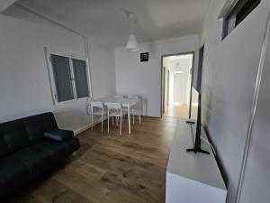 a living room with a couch and a table at T2 Res Chao Jardim in Vila Nova de Milfontes