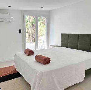 - un grand lit blanc avec 2 oreillers bruns dans l'établissement Peaceful Villa Between Sea And Pyrenees, à Perpignan