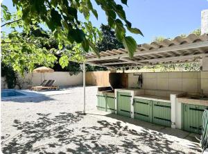 une cuisine sous une pergola à côté d'une piscine dans l'établissement Peaceful Villa Between Sea And Pyrenees, à Perpignan