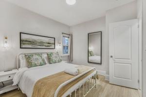 オシャワにあるChic 2 BR Urban Retreat Near Beach Free Parkingの白いベッドルーム(大型ベッド1台、鏡2つ付)