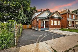 オシャワにあるChic 2 BR Urban Retreat Near Beach Free Parkingの塀と私道のあるレンガ造りの家