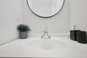 オシャワにあるChic 2 BR Urban Retreat Near Beach Free Parkingの洗面台と鏡のある白いバスルーム +13枚の写真