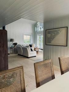een woonkamer met een witte bank en stoelen bij Modern Summer House With Pool In Risør in Risør