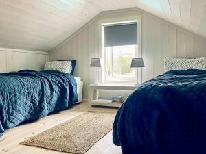 een slaapkamer met twee bedden en een raam bij Modern Summer House With Pool In Risør in Risør