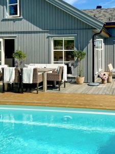 een tafel en stoelen op een terras naast een huis bij Modern Summer House With Pool In Risør in Risør +12 foto's