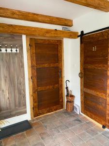 two wooden doors in a room with a tile floor at Rodinná Farma Humňany in Ražice