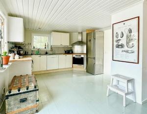 a kitchen with a refrigerator and a bench in it at Cozy Spacious Cottage By Water And Nature in Brastad +5 photos