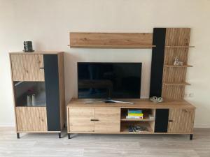 a wooden entertainment center with a tv and a book shelf at Ferienhaus Pusteblume in Halberstadt