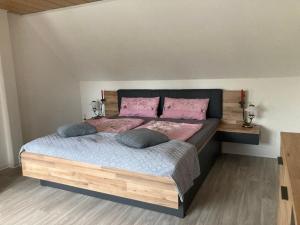 a bedroom with a large bed with pink pillows at Ferienhaus Pusteblume in Halberstadt