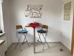 a table with two chairs and a sign on a wall at Ferienhaus Pusteblume in Halberstadt