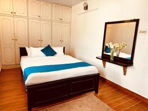una camera da letto con un letto e uno specchio di PSR Rooms and Cottages a Ooty Altre 2 foto