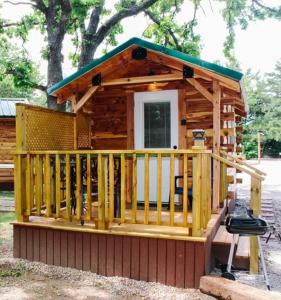 Cabaña de madera pequeña con porche y parrilla en #4 - Amish Log Camping Cabin Walk to the Water cabin, en Toronto