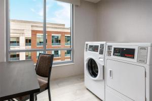 a laundry room with a washing machine and a table at Hyatt Place National Harbor in National Harbor