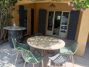 ein Tisch und Stühle vor einem Gebäude in der Unterkunft Villa climatisée avec grande piscine in Le Pouget